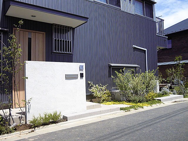 Simple but Attractive Exterior with White Gatepost and Plants