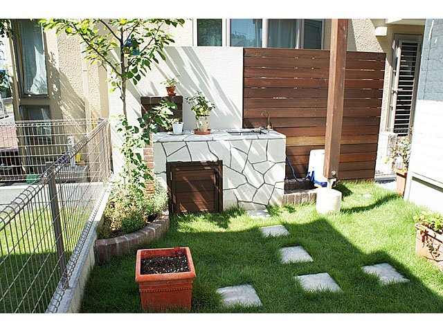 Stone Kitchen on Lawn and Brick Approach with Plants