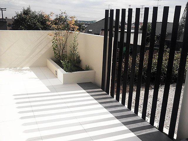 Simple Modern Exterior With White Tile and Black Wooden Sticks